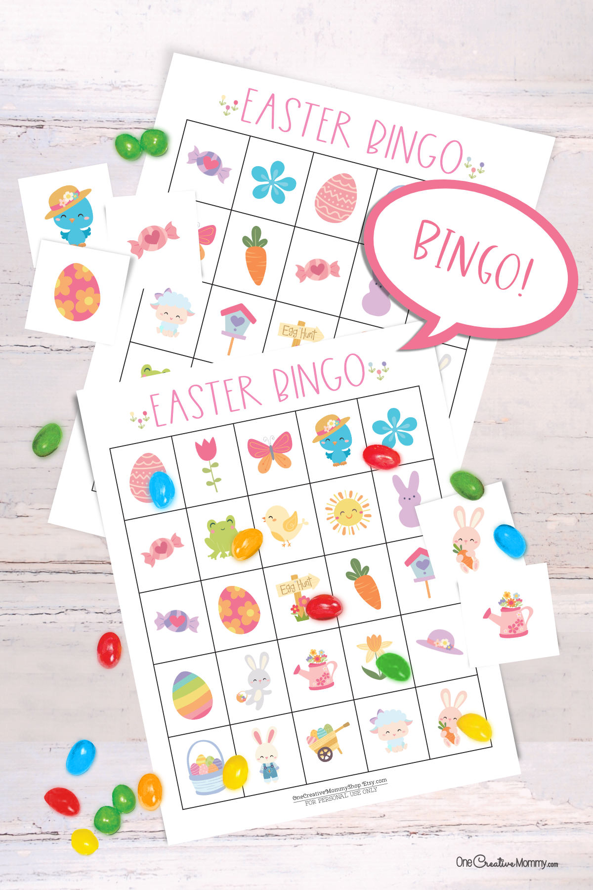 2 Easter bingo game cards are laid on top of each other on a white table. There is a small pile of jellybeans. Six calling cards are scattered across the game, and several spots are marked with jellybeans. A word bubble says Bingo!