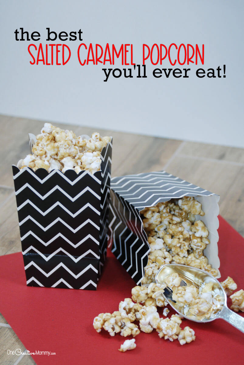 Salted Caramel popcorn spills out of an overturned black and white chevron-patterned popcorn bag onto a red table.