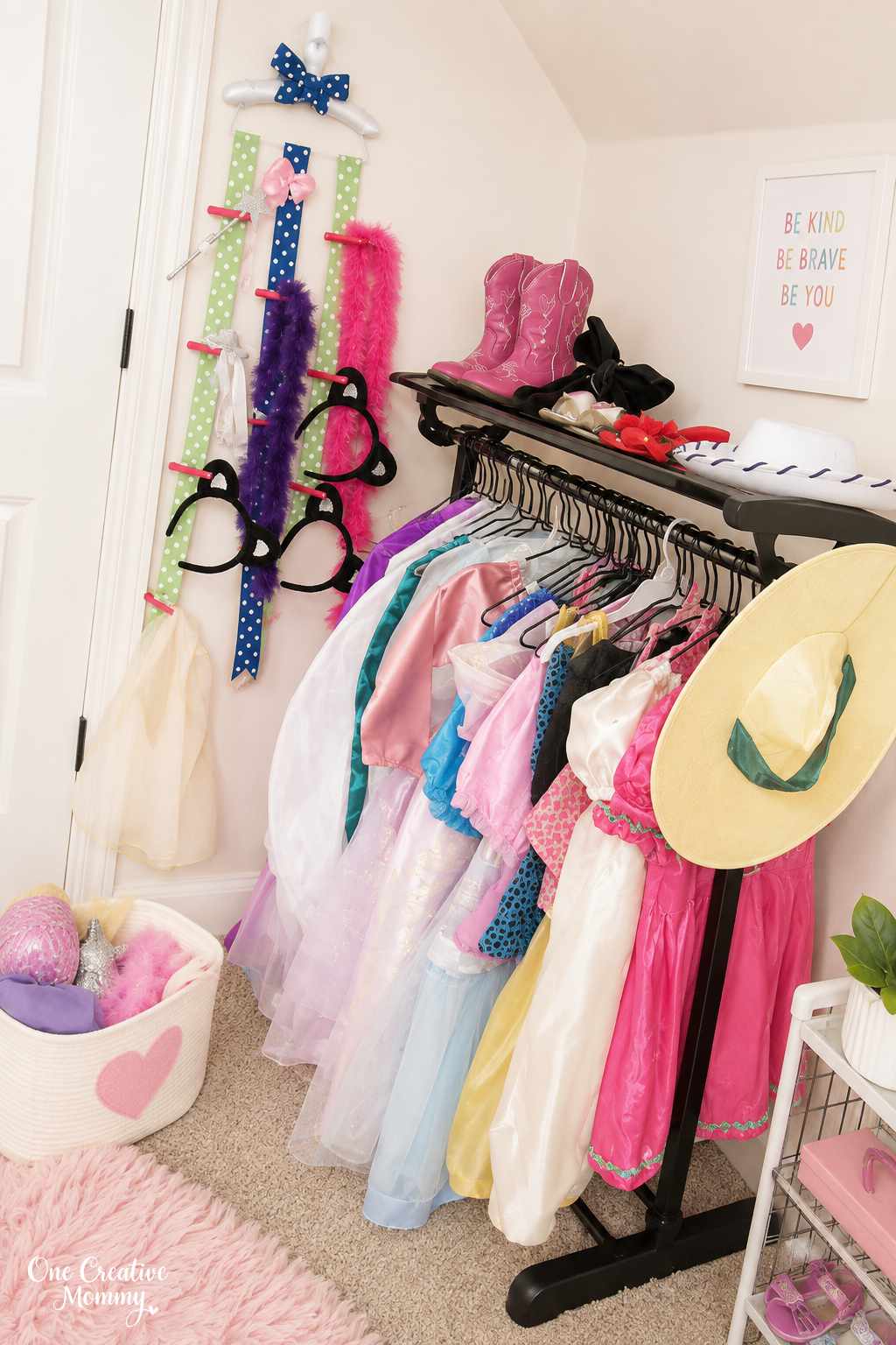 Kids’ dress-up clothes organized on a clothing rack with costumes, hats, boots, boas, and accessories.