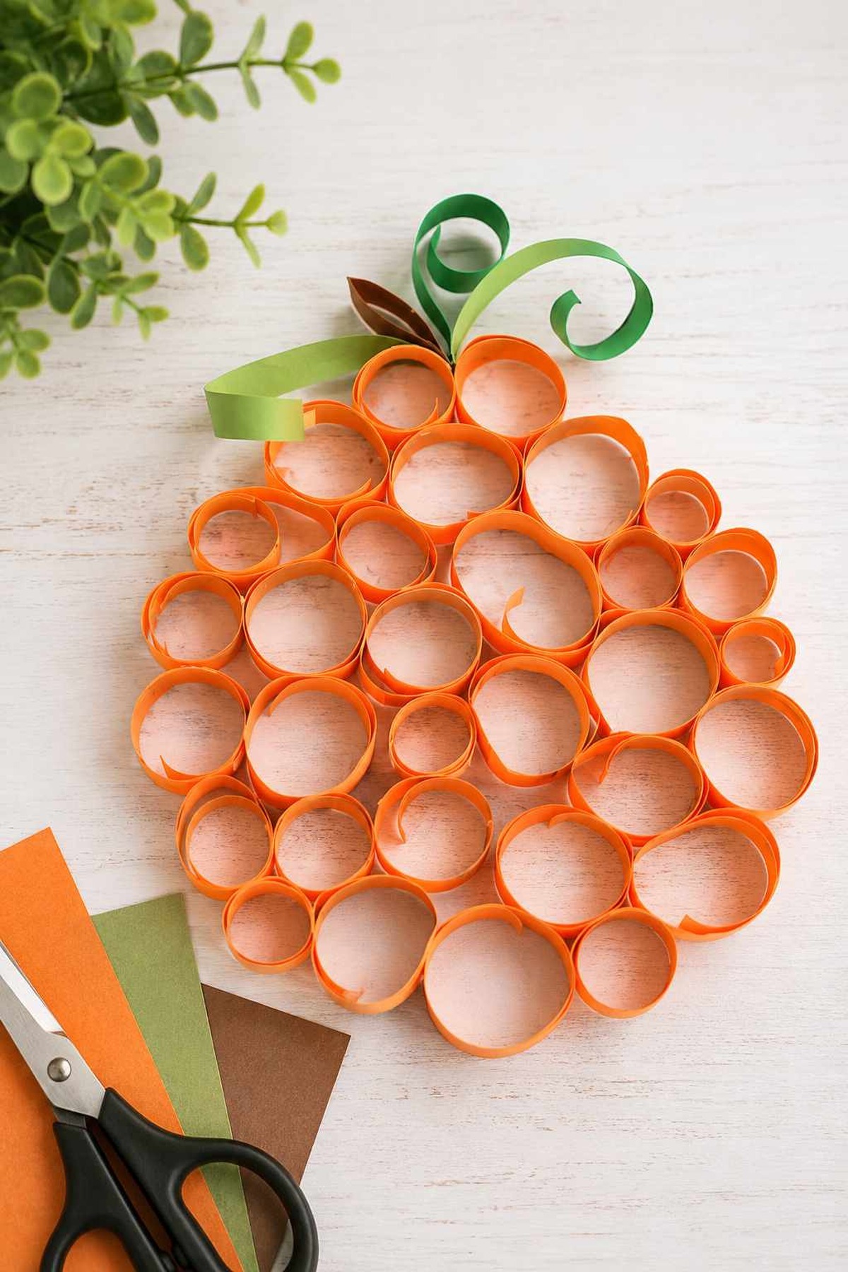 Easy rolled paper pumpkin craft made with orange paper strips