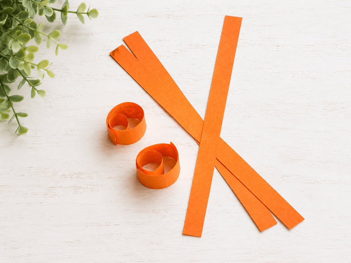 Orange paper strips rolled into circles for a pumpkin craft