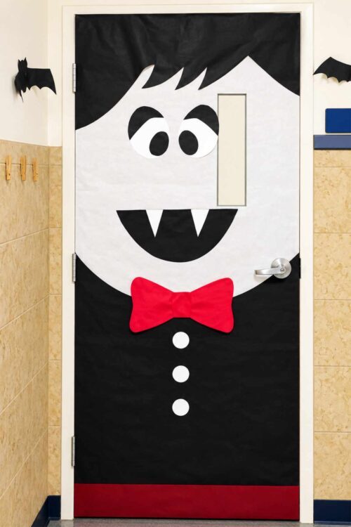 Vampire Halloween classroom door decoration with fangs and a red bow tie