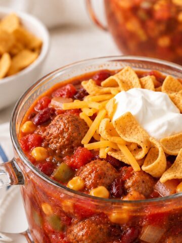Meatball chili topped with Fritos, shredded cheese, and sour cream